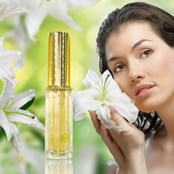 A bottle of Épicé Fragrance spray with a clear bottle and gold lid. Woman holding a flower against her cheek.